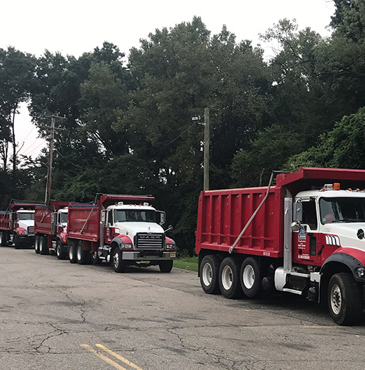 three dump trucks on road